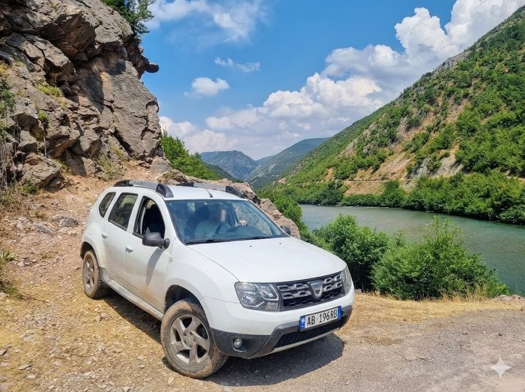 Cheap Car Rental in Albania: Budget, Automatic & 4x4 Options 8 Cheap car rental in Albania – Dacia Duster 4x4 on a remote mountain road near Lake Komani.