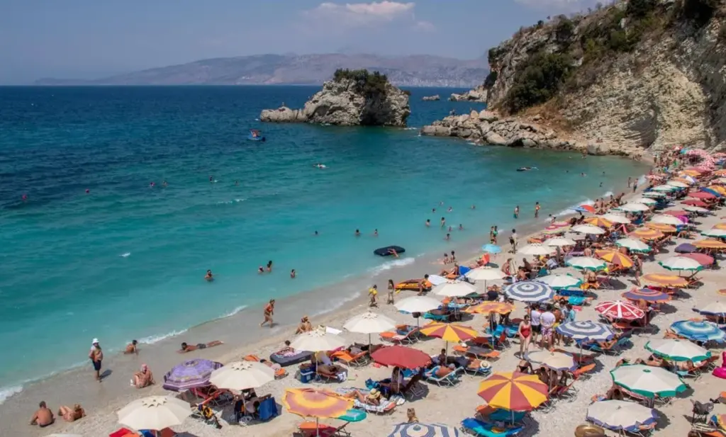 Crowded summer day at Mirror Beach near Saranda – a popular stop along the Ksamil car rental coastal route in southern Albania.
