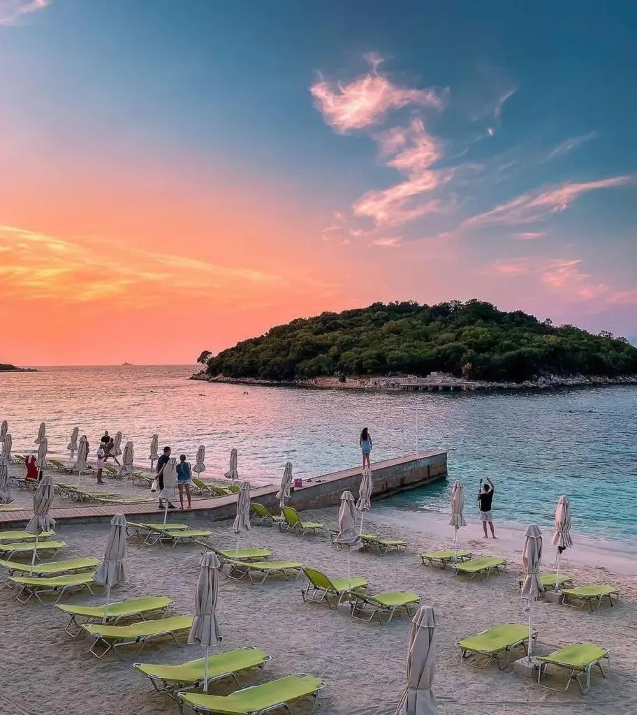 Ksamil beach with clear blue waters and nearby islands, ideal for travelers using Ksamil car rental services to explore Southern Albania.
