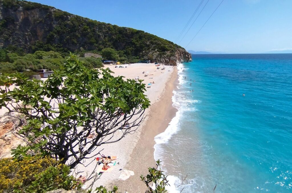 High-angle view of the secluded Gjipe Beach in Albania, a prime example of rough terrain often requiring SUV rental in Saranda for access.