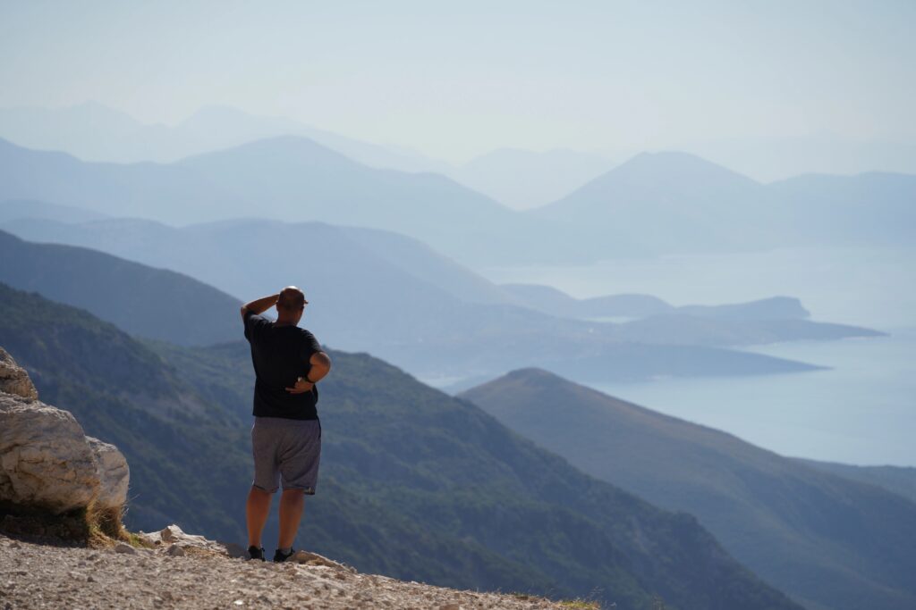 Panoramic view of the Albanian Riviera coastline from the SH8 road, with mountains descending into the Ionian Sea