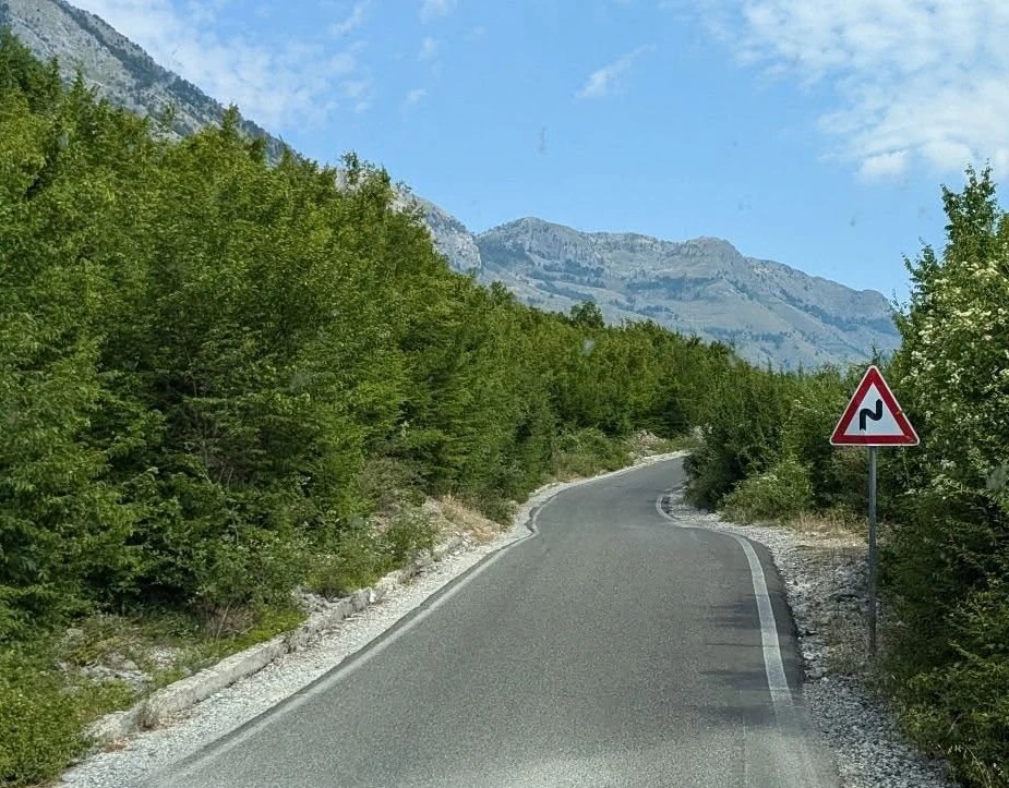 Best car for the Albanian Alps – narrow mountain road to Theth showing sharp turns and minimal shoulder clearance

