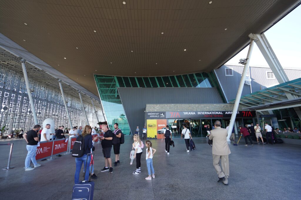 Tirana International Airport (TIA) Departures terminal exterior, near the car rental pickup zone.