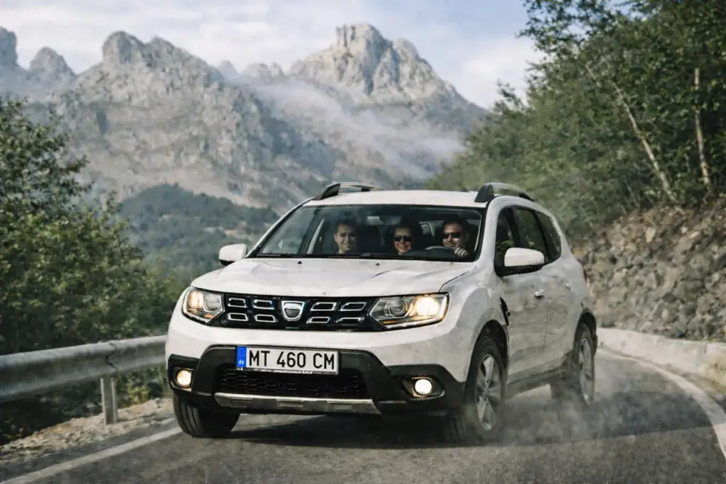 Dacia Duster Rental Albania: 2WD vs 4WD | Theth Road Test | Real Fuel Costs 1 White Dacia Duster rental car parked on a winding mountain road in Albania on the way to Theth village.