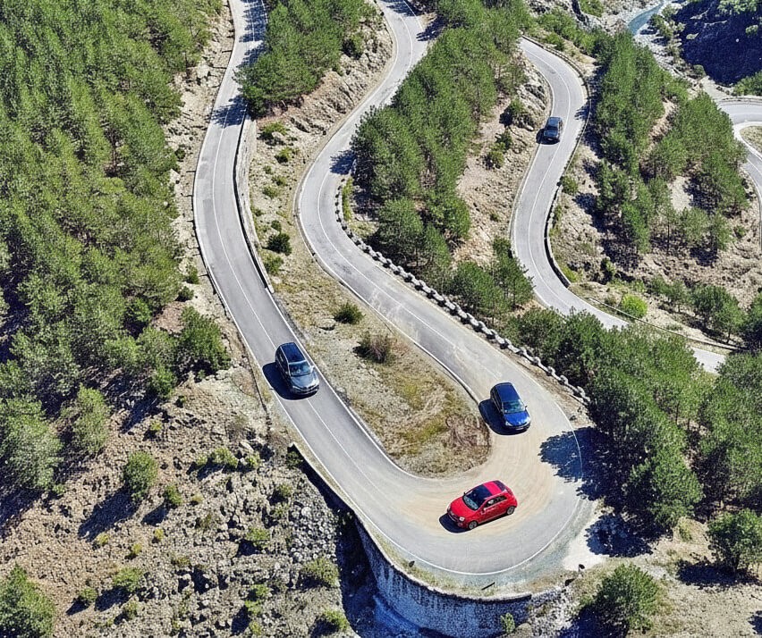 Automatic Car Rental in Albania: No-Stall Driving for UK, US and Aussie Travellers 1 Drone view of the winding SH5 national road in Albania, showing steep mountain curves ideal for automatic car rental driving.